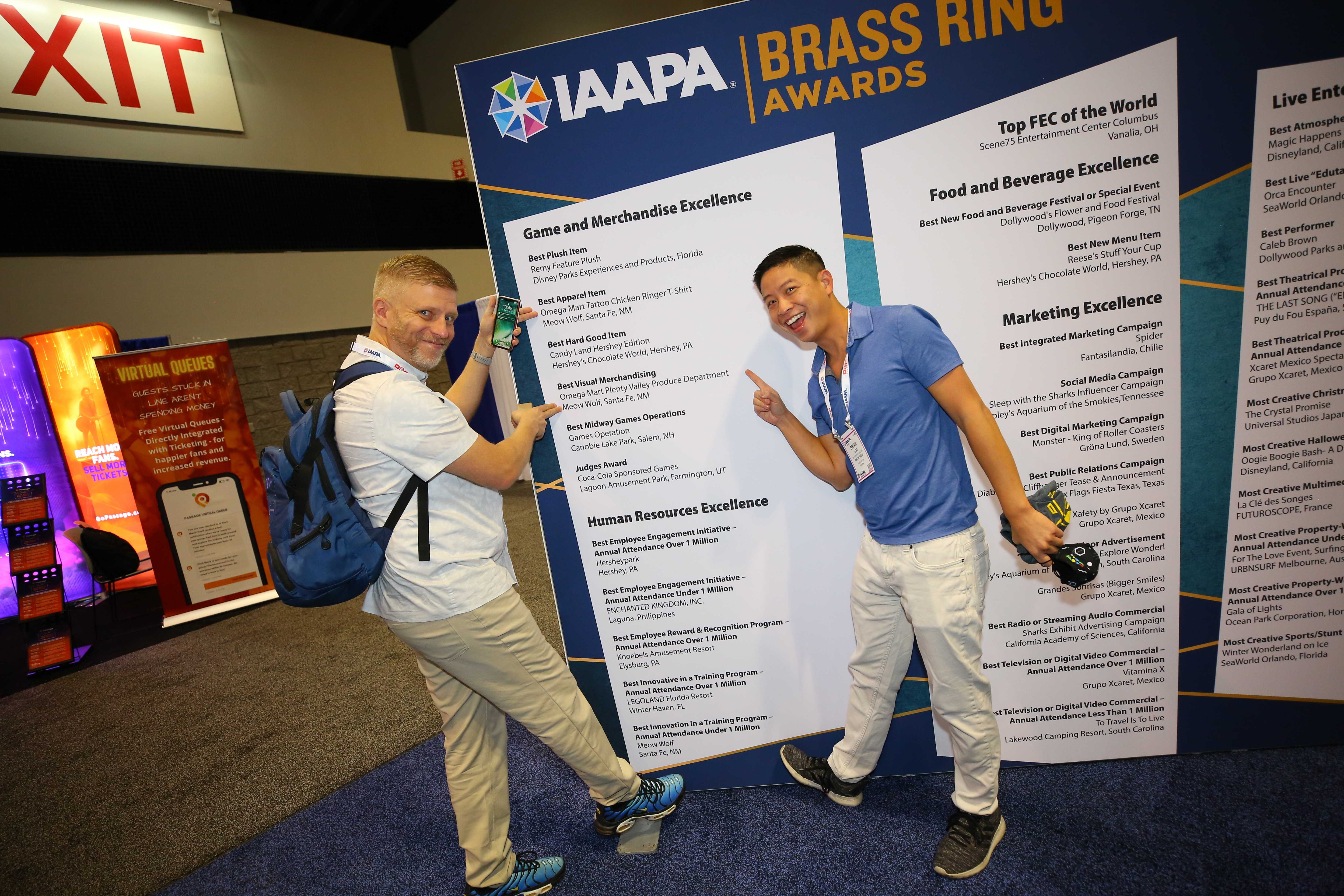 Award winners pose with the posting of their win at IAAPA Expo