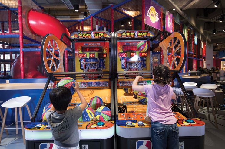 Kids play a basketball arcade game at Shanghai NBA Playzone