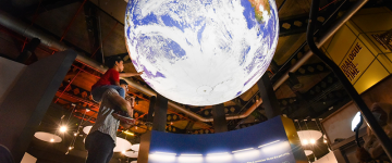 Child enjoys giant earth globe 