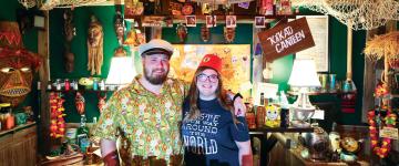 Jordan Hill and his wife, Sarah Hill, posing at the Kakau Canteen tiki bar that Jordan created from scratch