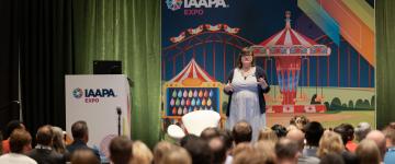 Speaker Lauren Tidmore, Ed.D. is standing on a podium during the Fix Your Trainwreck EDUSession held at IAAPA Expo 2023