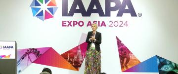 Speaker Peta Wittig, owner and director of Peta Wittig Consulting, is standing on a podium during her EDUSession held at IAAPA Expo Asia 2024