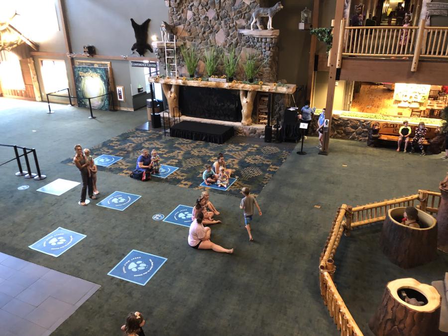 Spaced out families gather in the common area of Great Wolf Lodge