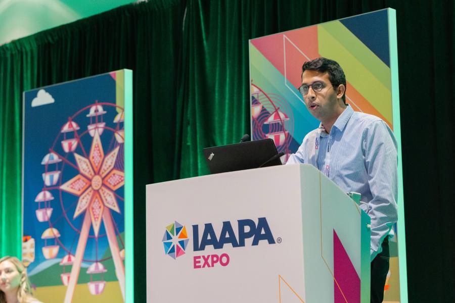 Speaker Anil Rao is standing on a podium during the Operational Health: How Efficiencies in Labor and Waste Drive Sustainability and Profitability EDUSession at IAAPA Expo 2023