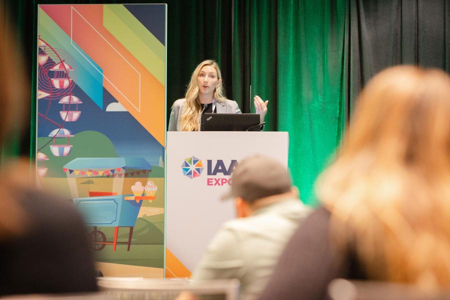Speaker Taylor Ceithaml is standing on a podium during the Operational Health: How Efficiencies in Labor and Waste Drive Sustainability and Profitability EDUSession at IAAPA Expo 2023