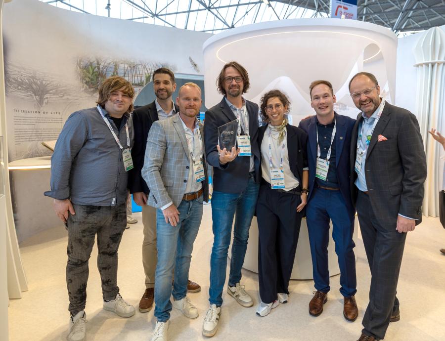 Leaders wearing business casual attire stand and smile inside the Tomorrowland booth.