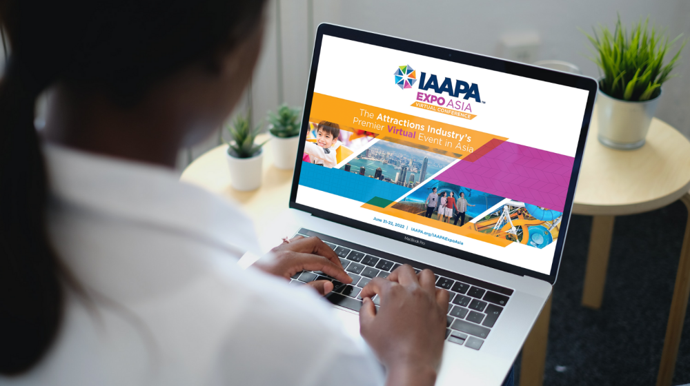 Woman looks at a laptop screen with details about IAAPA Expo Asia Virtual Conference
