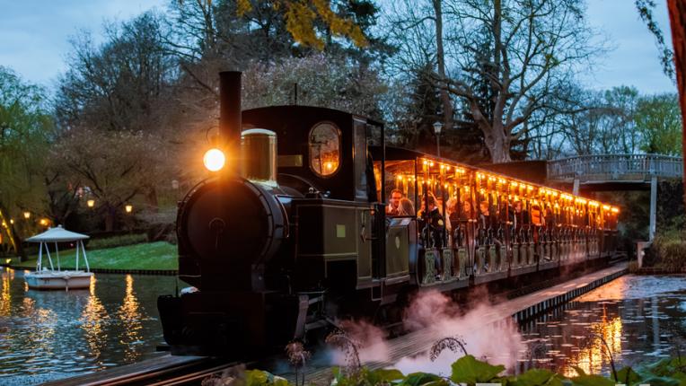 A train at Efteling that operates with electric power rolls down the tracks.