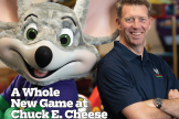 Photo of Chuck E. Cheese mascot standing next to CEO David McKillips on the Jan/Feb 2022 cover of Funworld Magazine